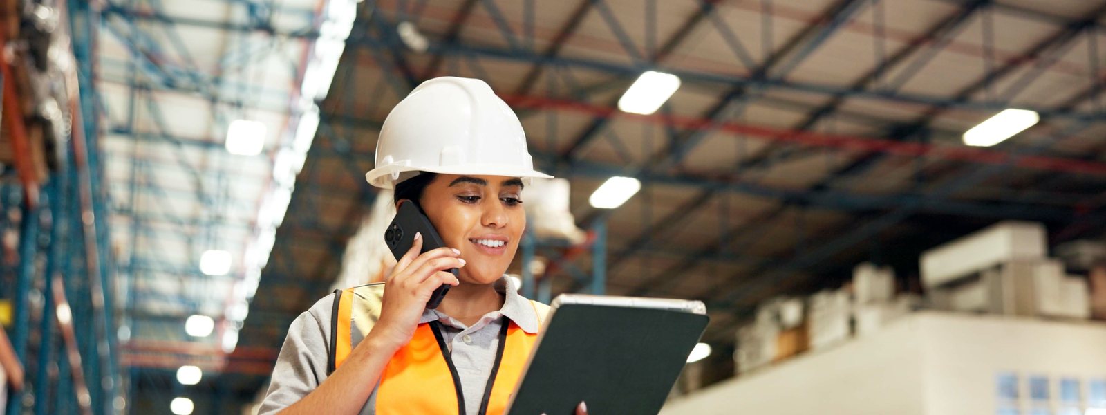 Medewerker belt in het magazijn met een tablet in de hand